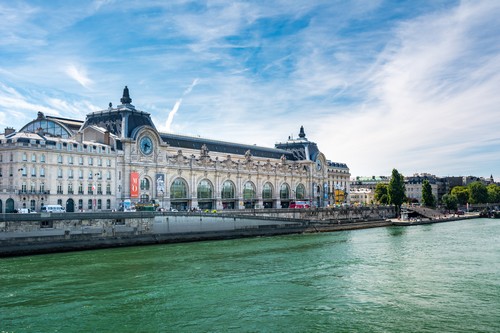 Paris, France - August 14, 2016: Orsay Museum, seen from the right bank of the Seine river. Notice that the museum building was originally a railway station. (Paris, France - August 14, 2016: Orsay Museum, seen from the right bank of the Seine river. 